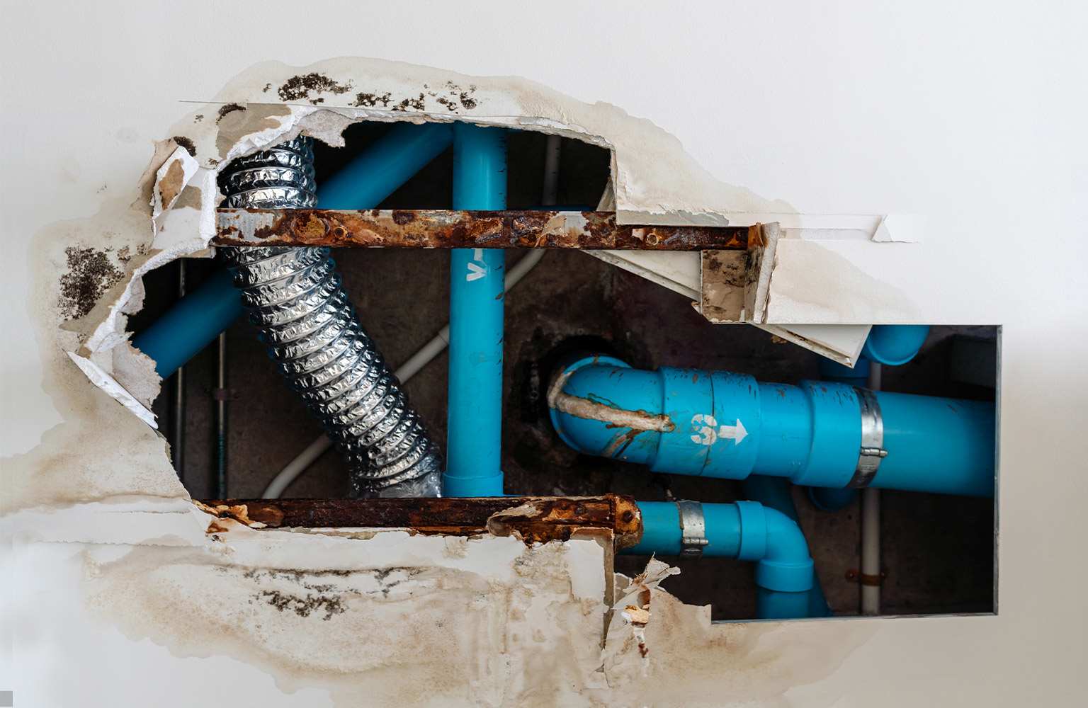 broken wall with exposed pipes