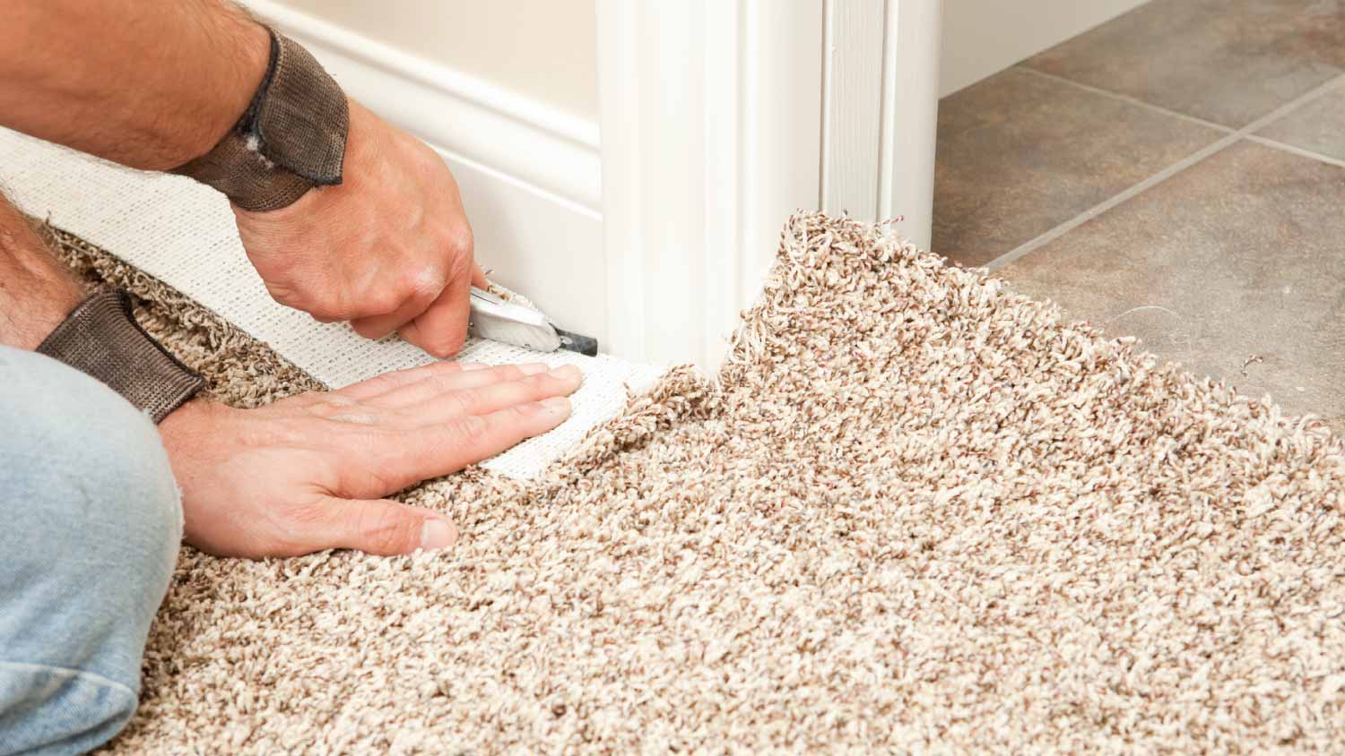 A man using a knife to trim wall edge