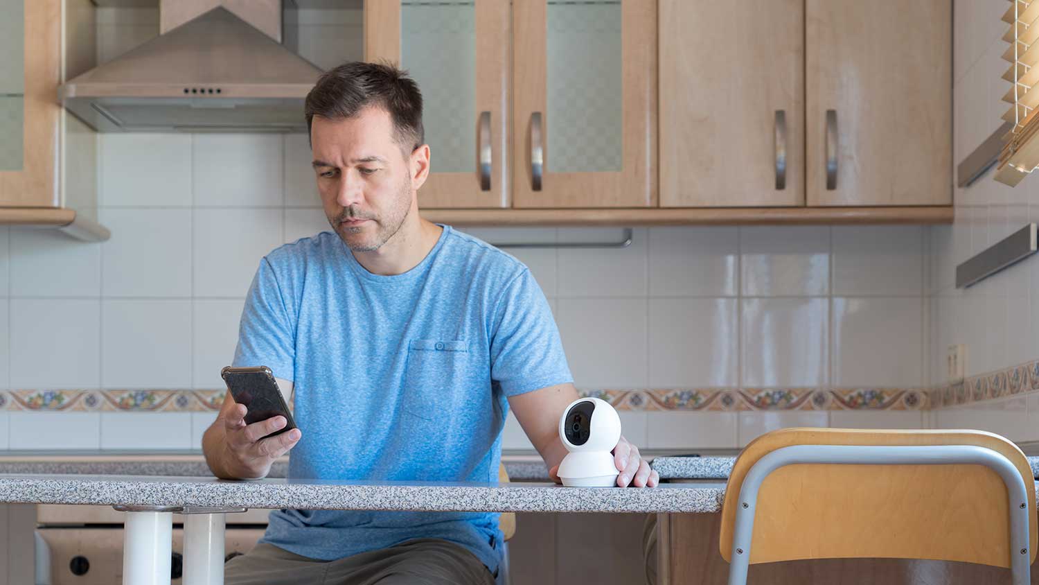 Man setting up security camera with a smartphone