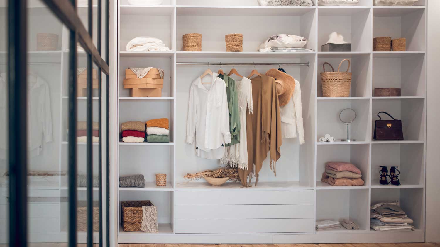 A white wardrobe with shelves filled with clothes and shoes