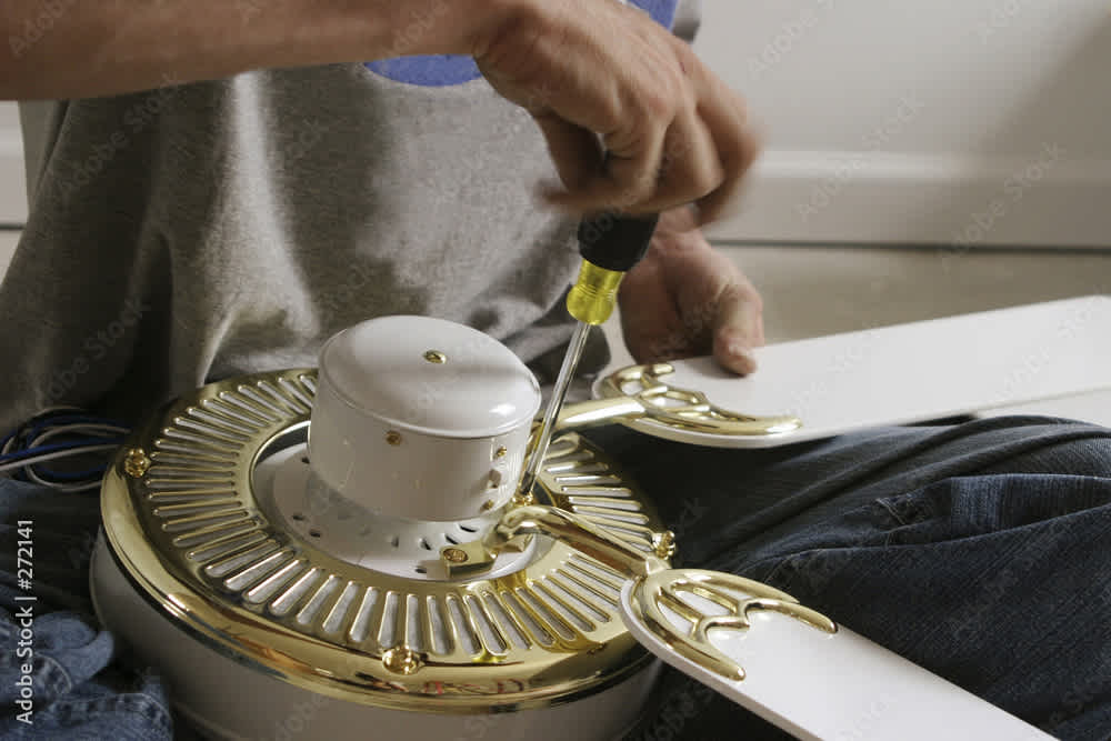 A professional assembling a ceiling fan