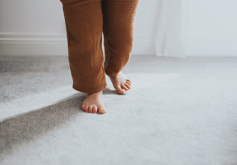shot of child's feet on beige carpet