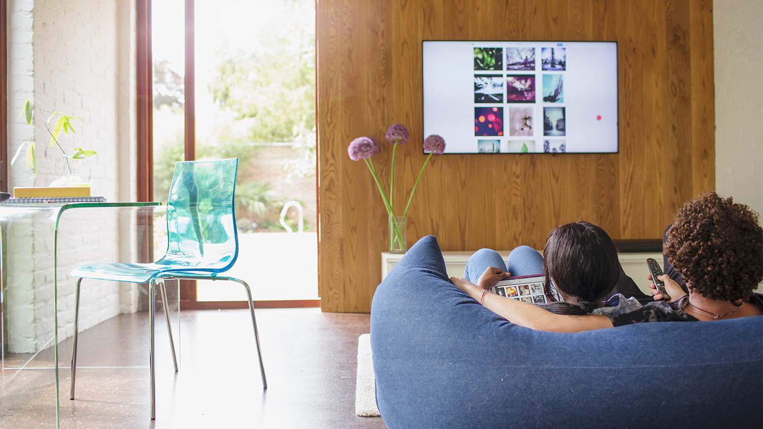 Young couple streaming photos from digital tablet to TV