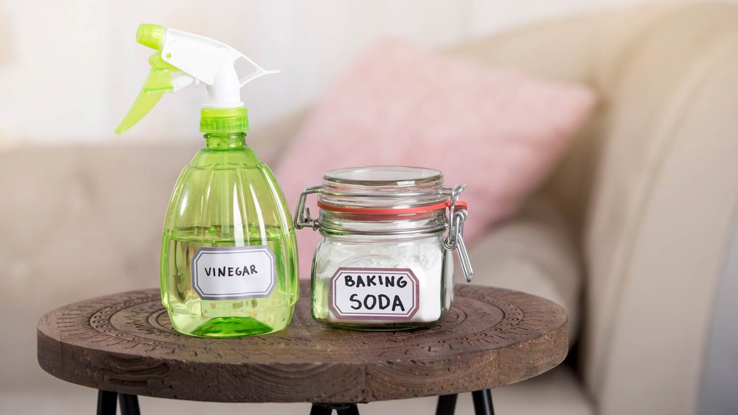 A vinegar spray bottle and a jar filled with baking soda