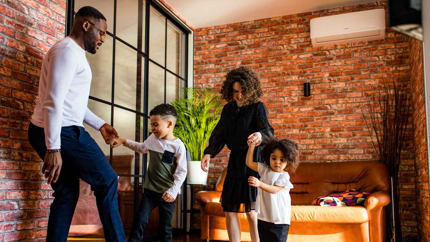 A family of four playing in the living room