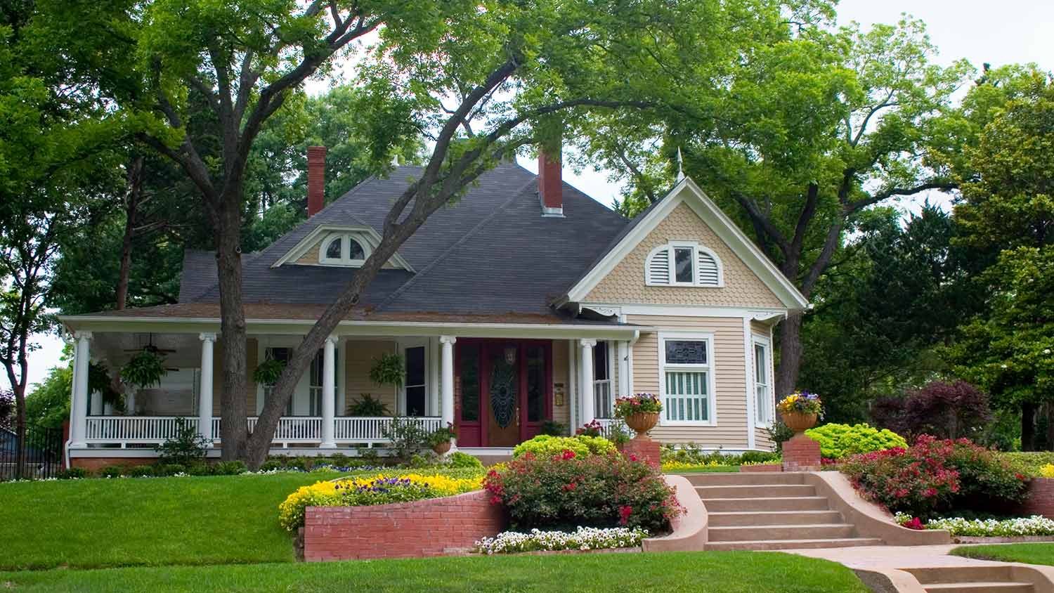 Large trees surrounding classic house