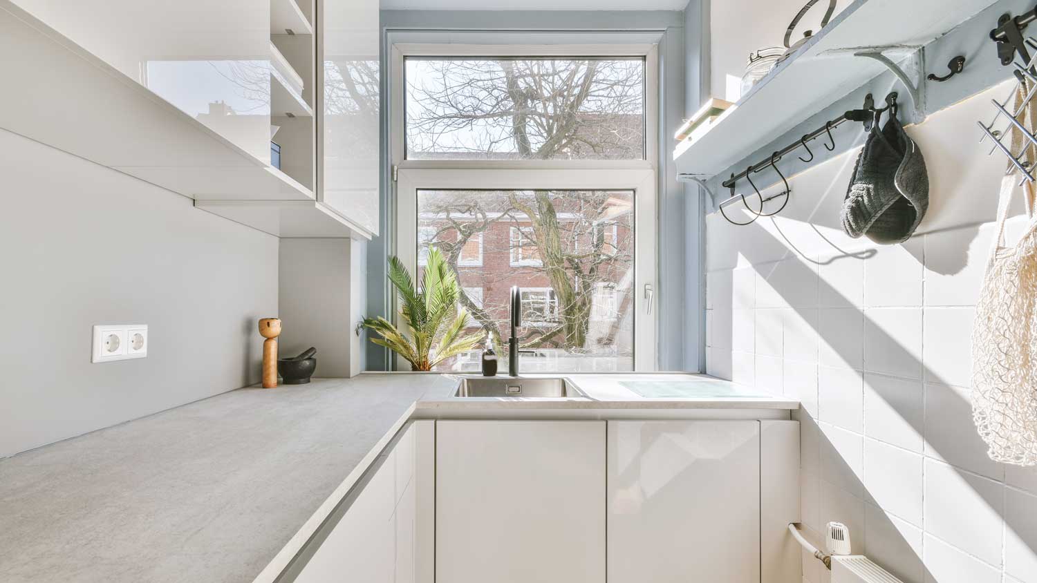 A well organized small kitchen with a window overlooking nature