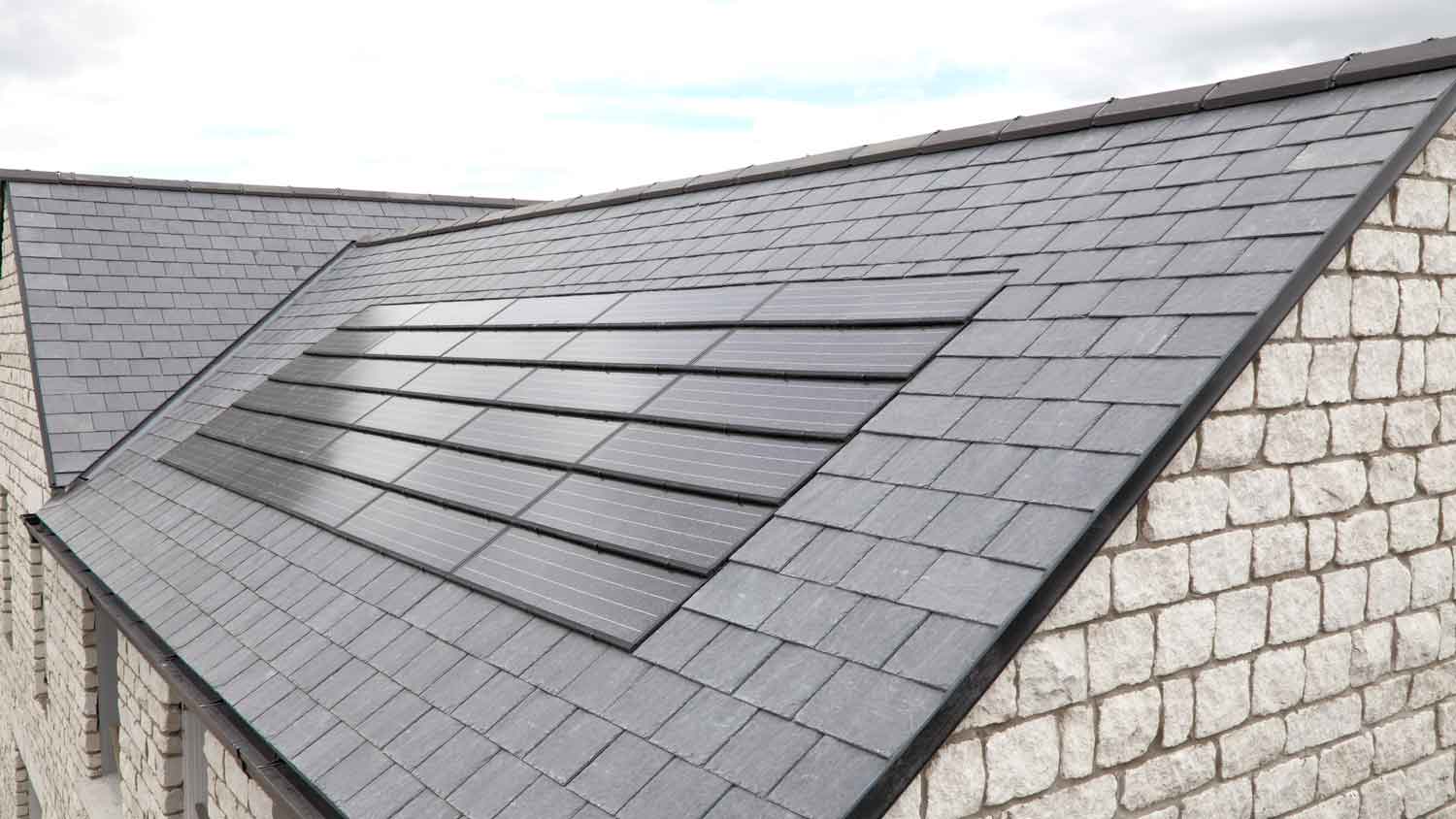 A black tiled roof with solar shingles installed