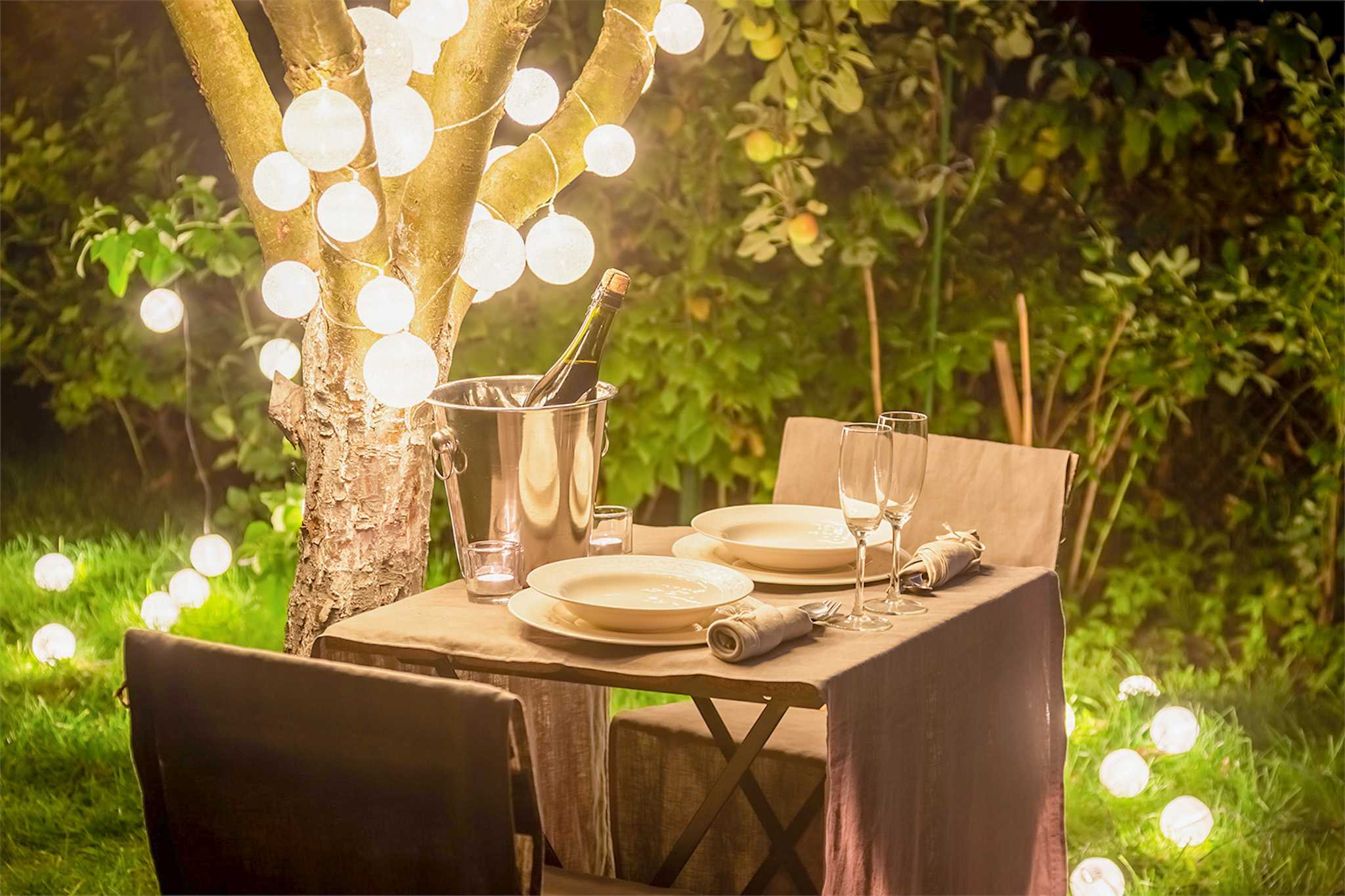 Table set for dinner outside with romantic lighting