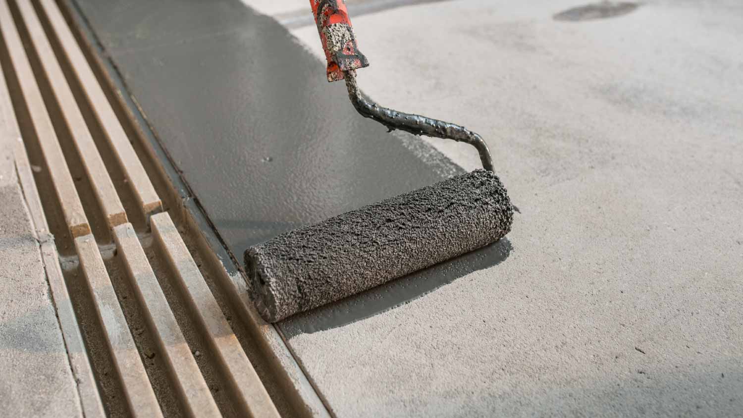 Worker painting concrete floor