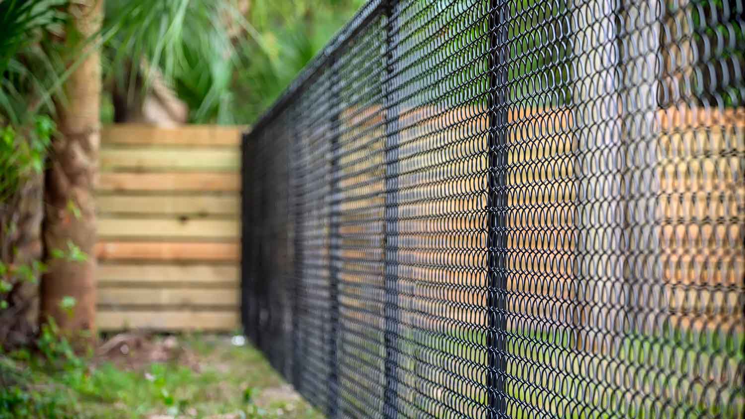 A chain link fence in the backyard of a house