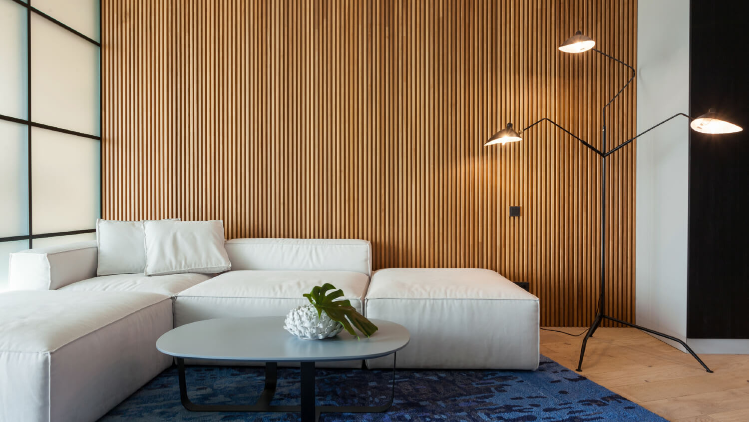 Modern living room with wood paneling behind sofa