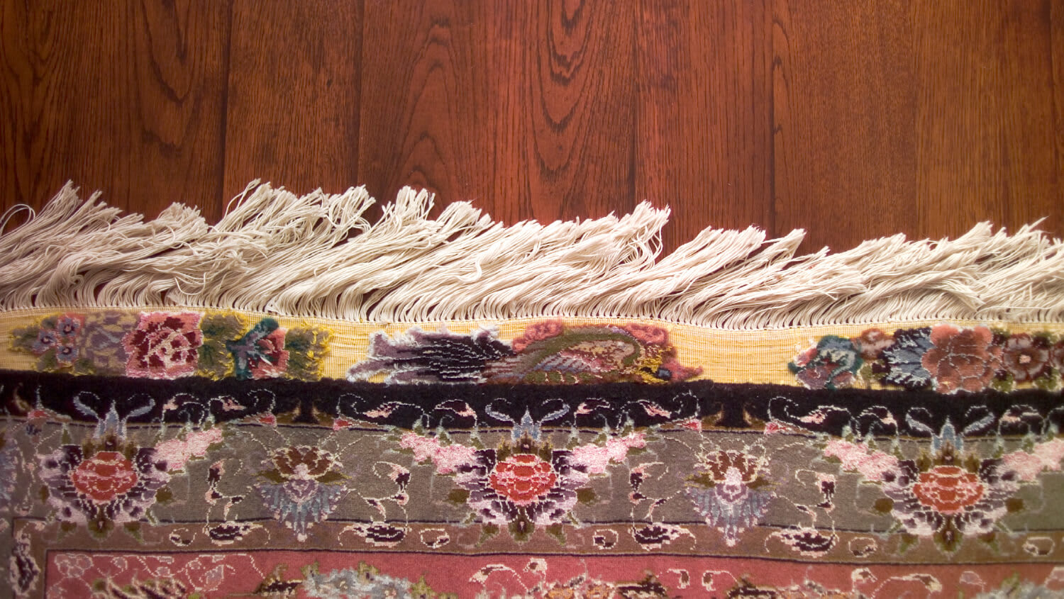 Fringed carpet on wood flooring