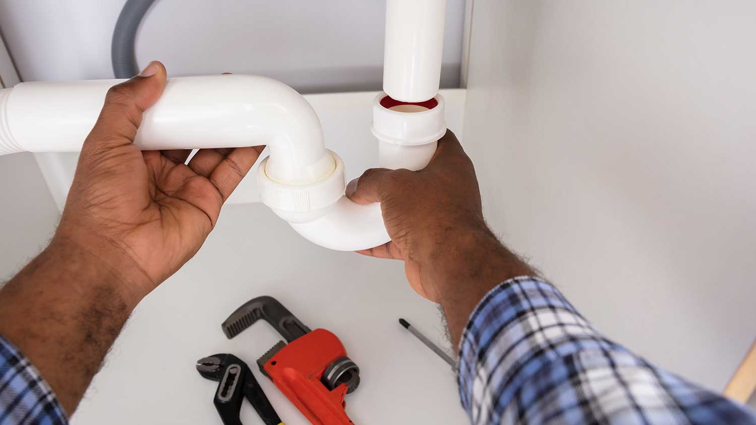Plumber removing p-trap from kitchen sink