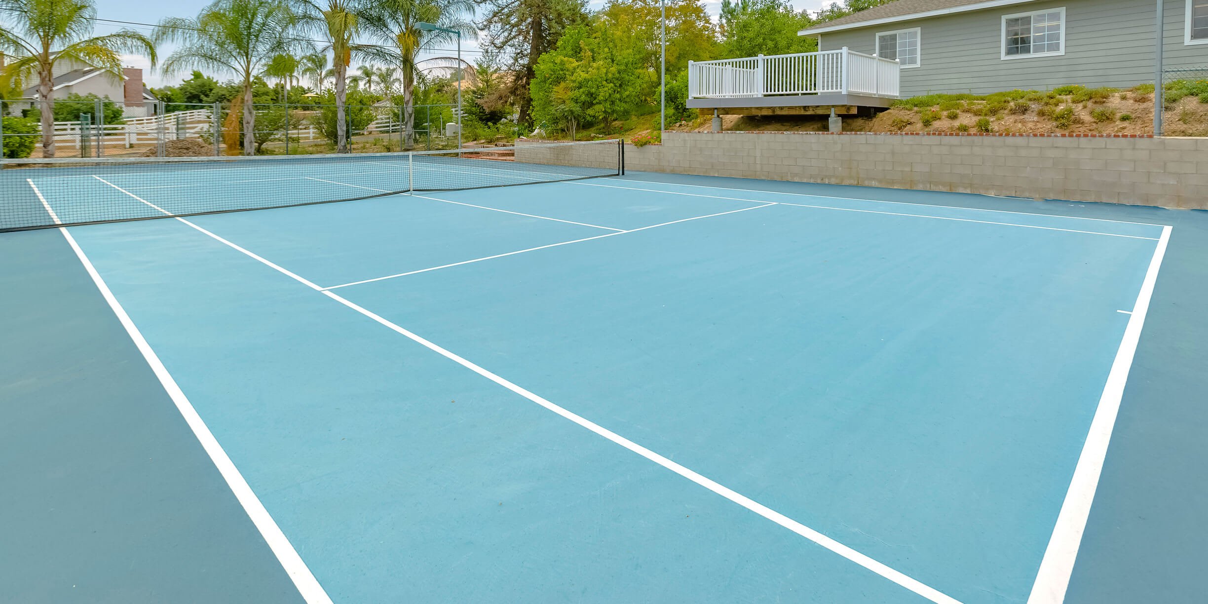 Tennis court with homes in the background
