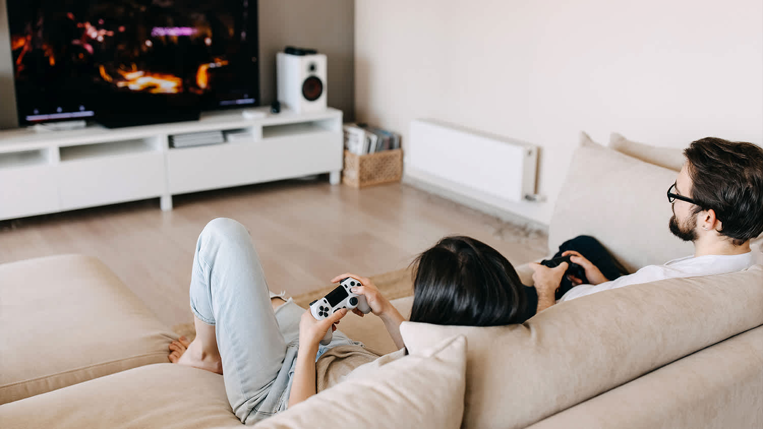 two people sitting on the couch playing video games