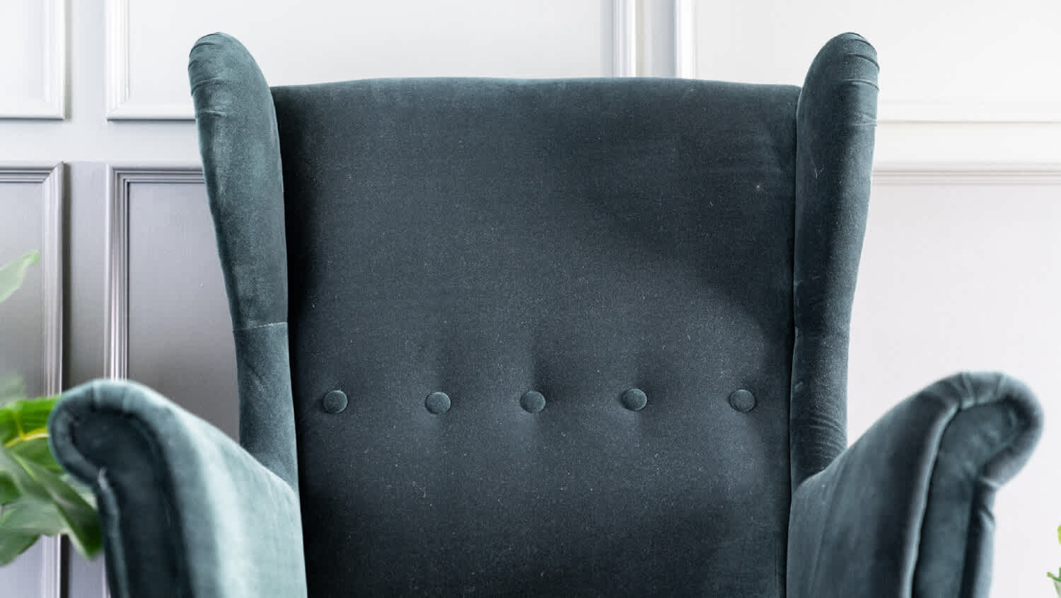 Close up high back green velvet armchair