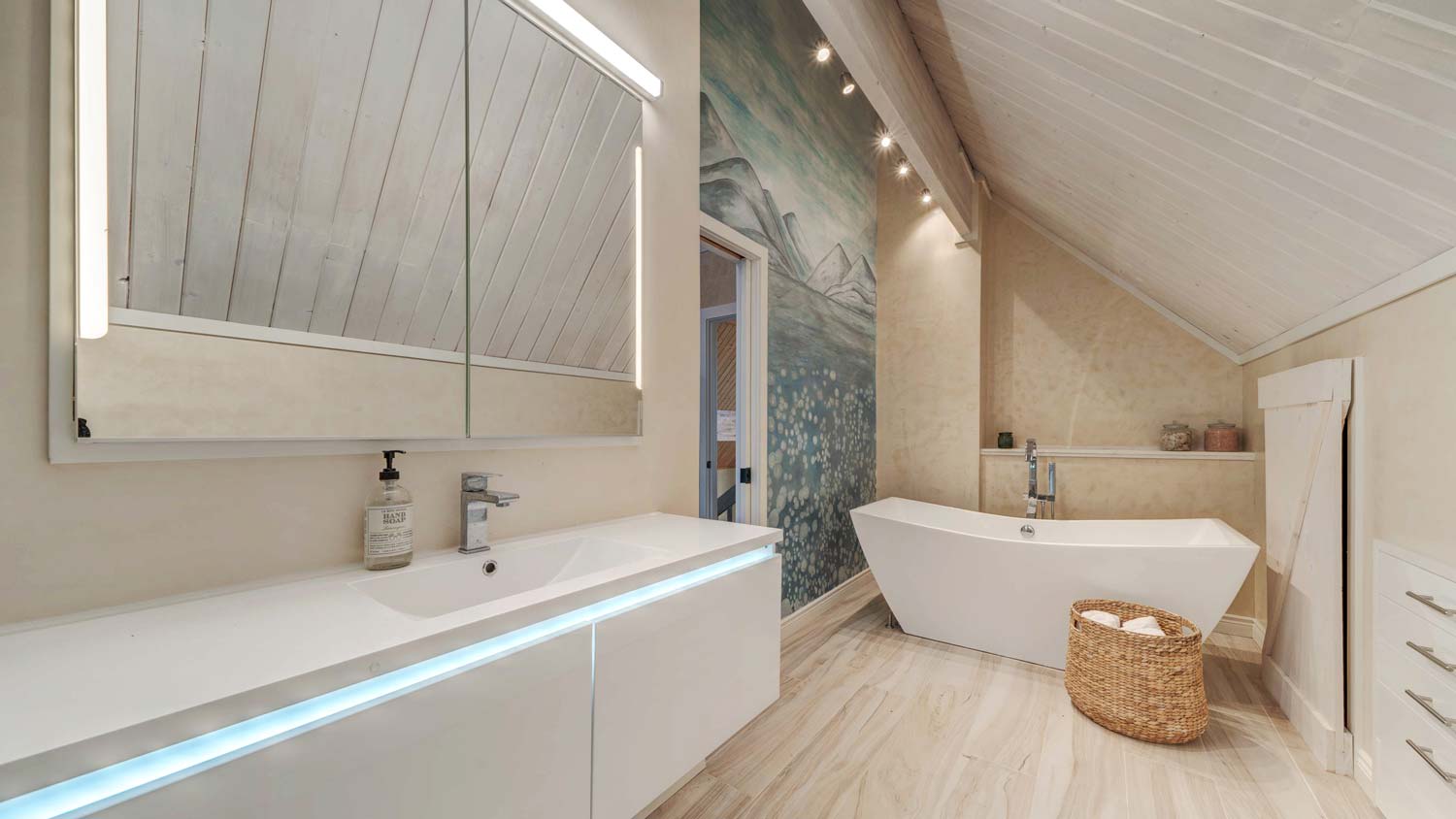 A minimal bathroom with vaulted ceiling and a white bathtub