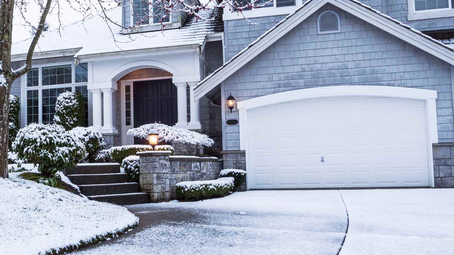A house and its driveway covered in snow