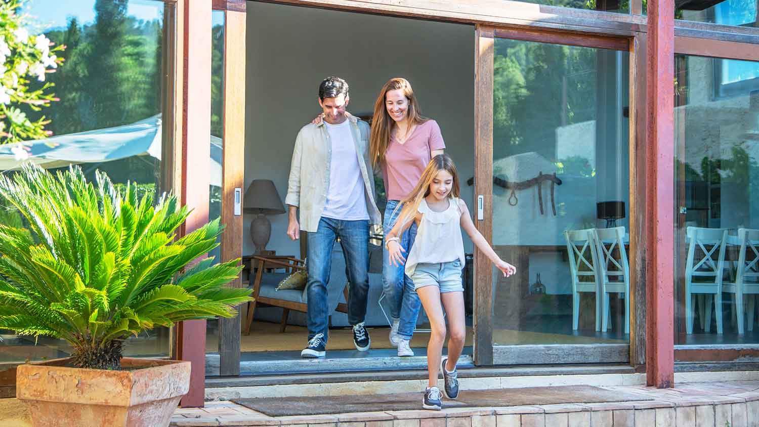 Smiling family walking out the patio door