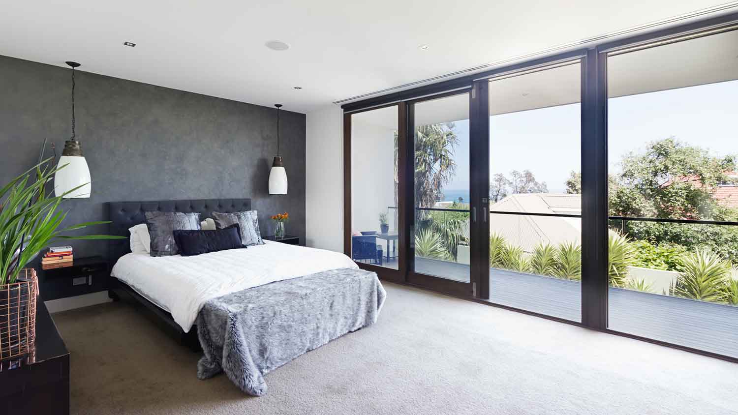 Luxury master bedroom with tall sliding glass doors