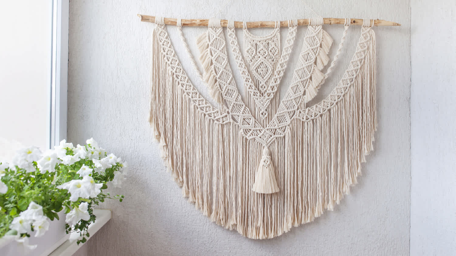 Handmade cotton wall hanging next to flowers