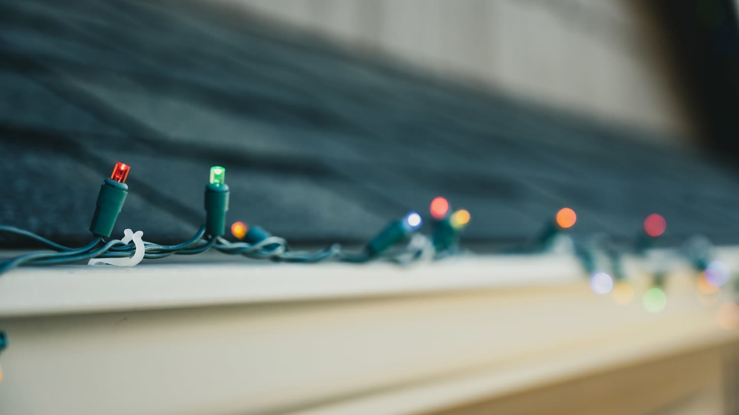 Outdoor Christmas lights tied on the roof with plastic clips