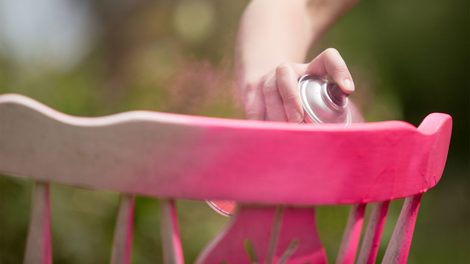 Someone spray paints a chair pink