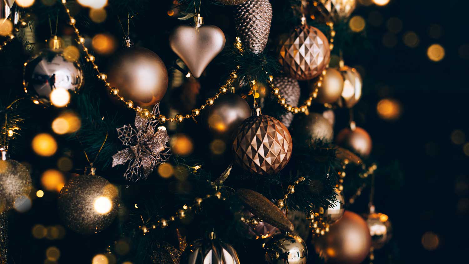 Close-up of a black Christmas tree with gold ornaments
