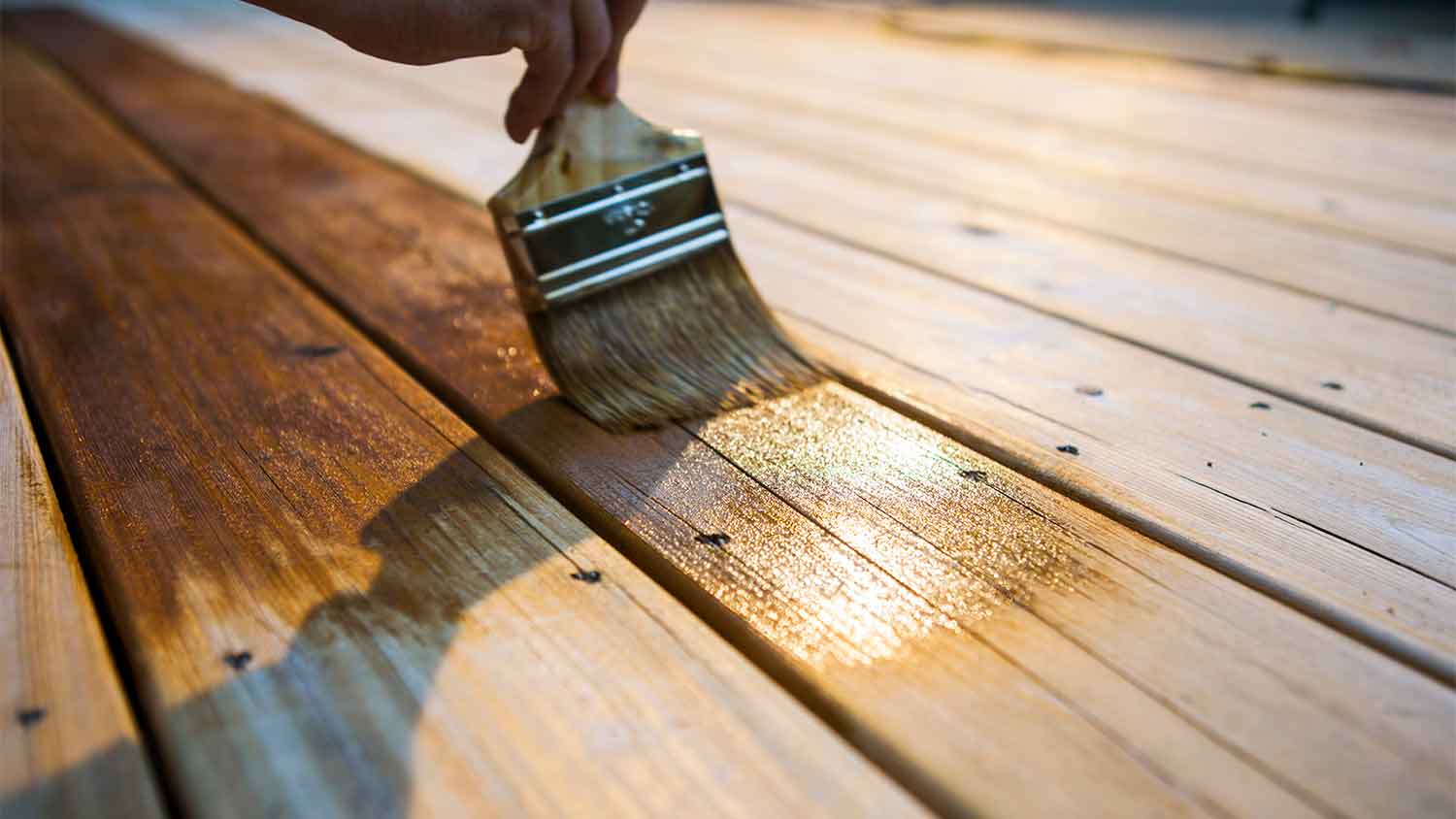 A closeup of someone staining wood