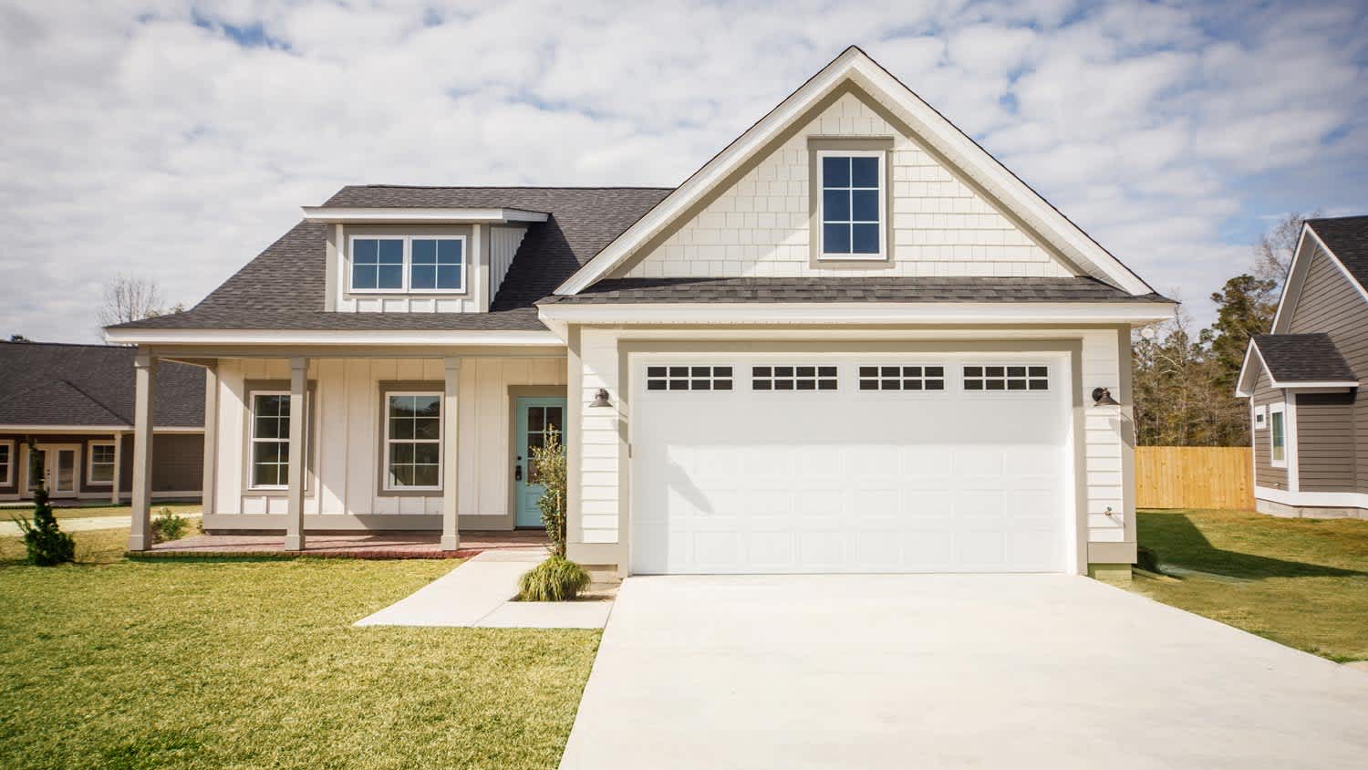 A cottage house with a white garage door