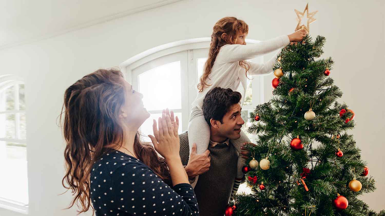 A family decorates a christmas tree