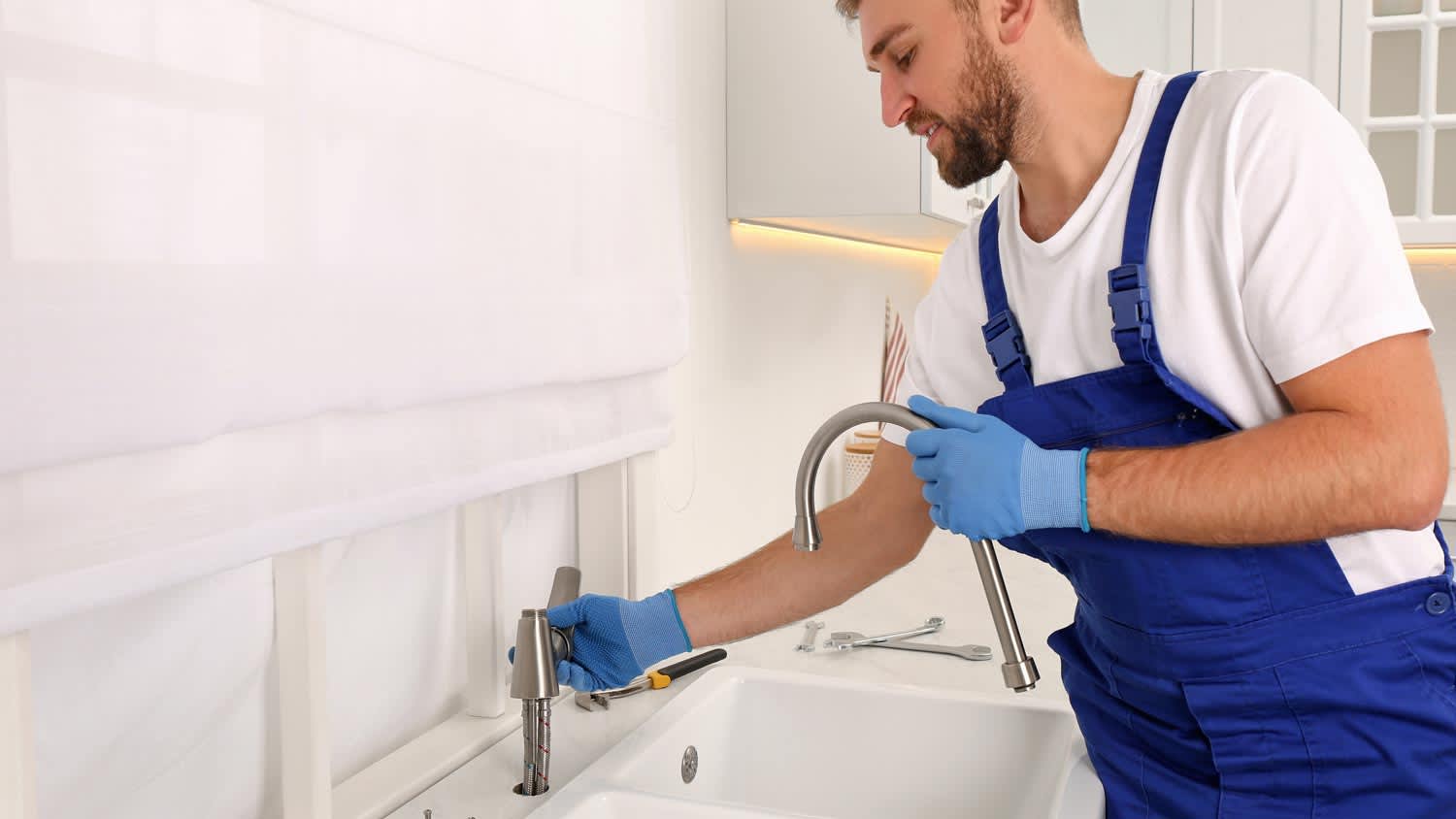 A plumber replacing a faucet
