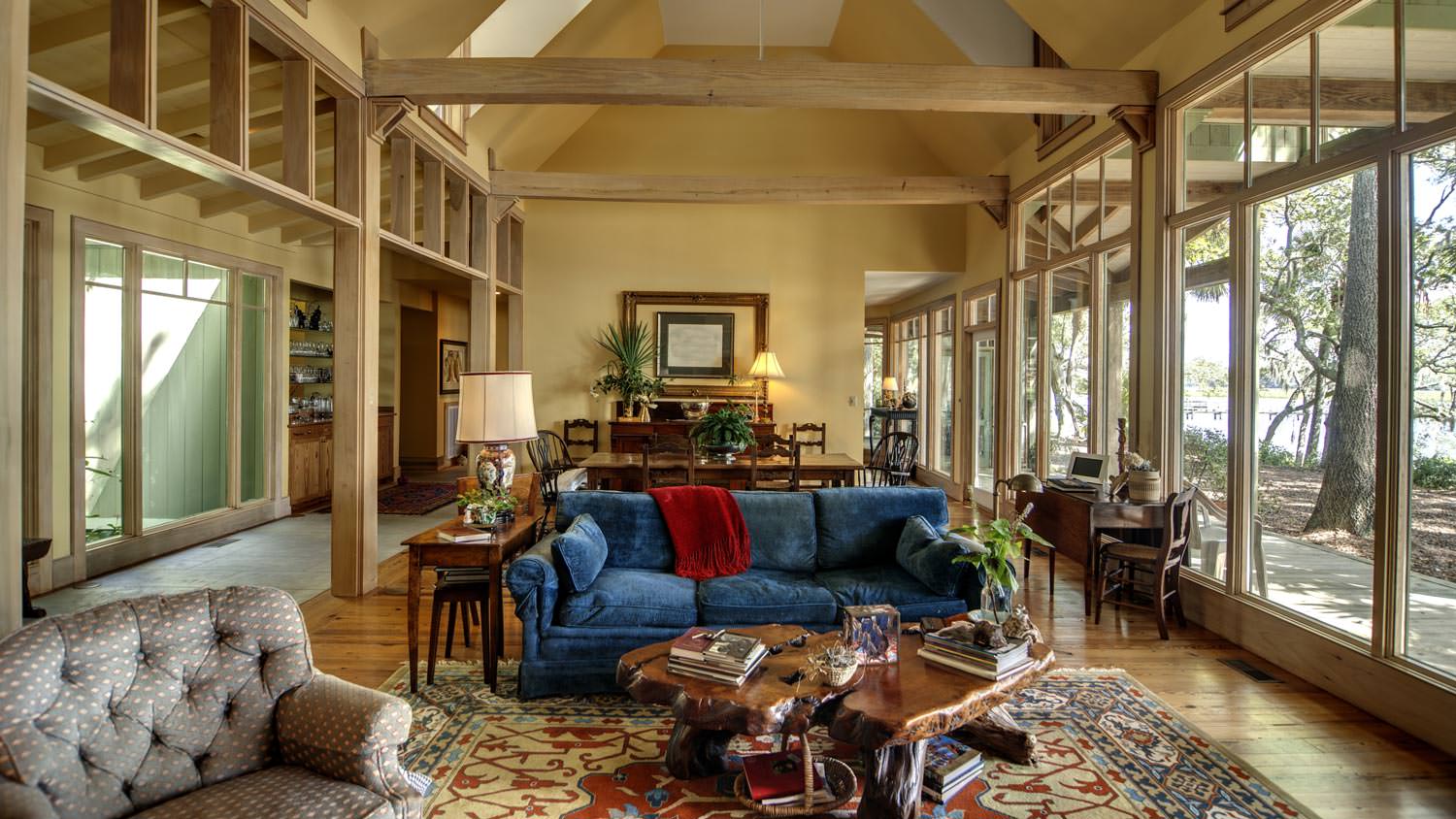 A living room with vaulted ceiling and large windows