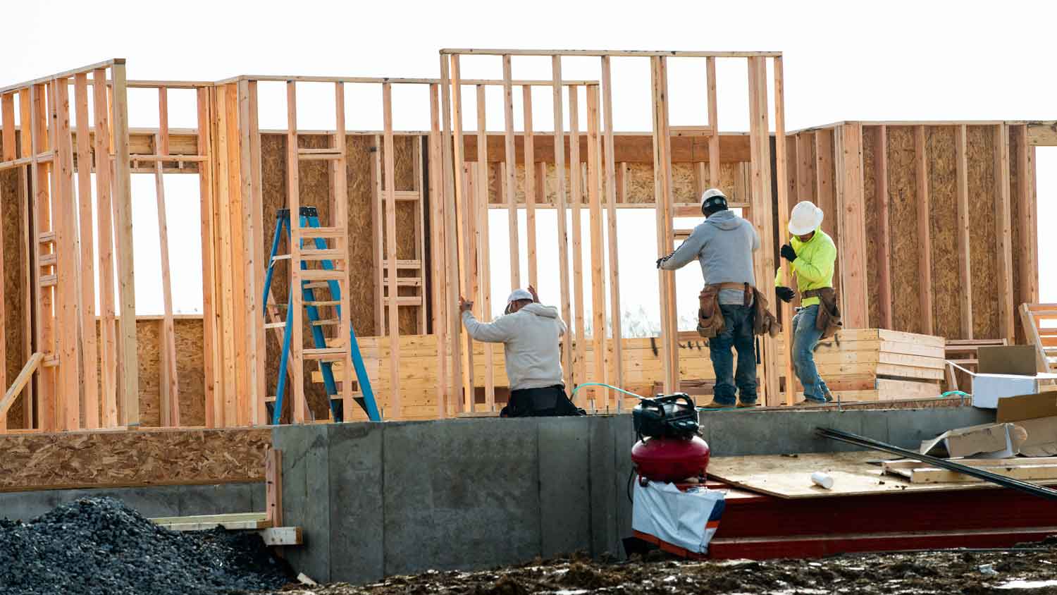 Workers working on framing a house