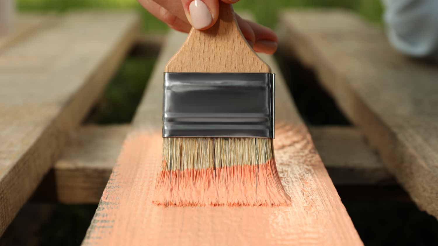 Woman painting wooden surface
