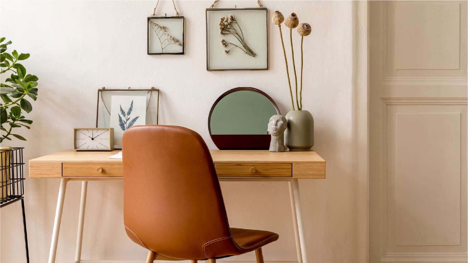 stylish modern desk with leather chair and framed art