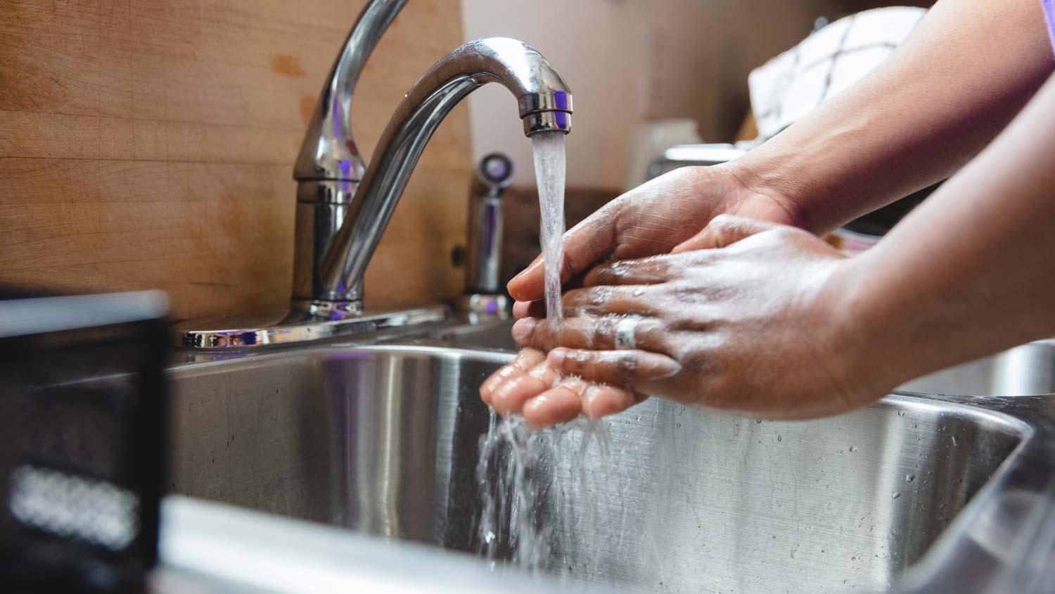 A man washing his hands in the sink