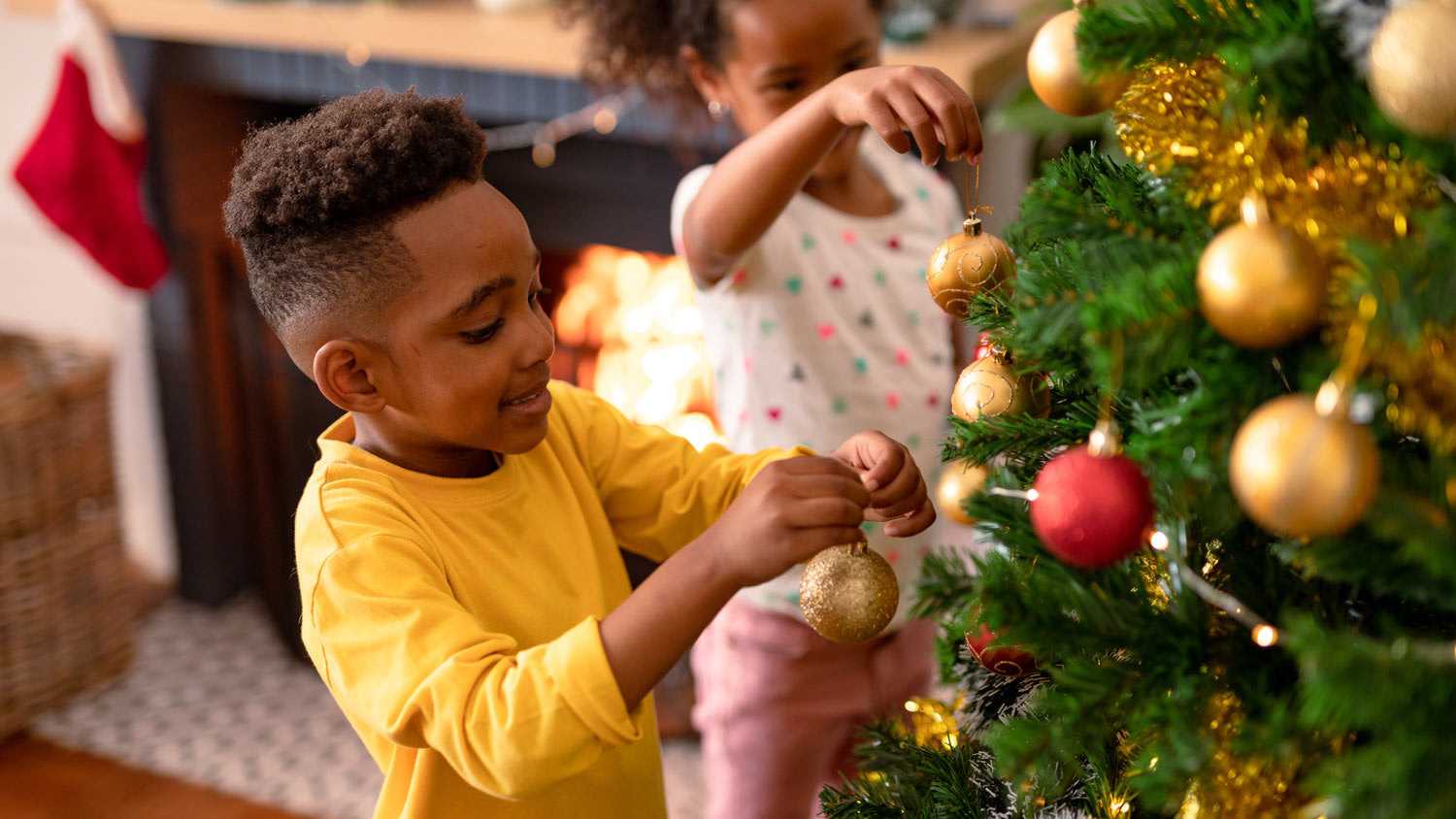 Siblings decorating a Christmas tree