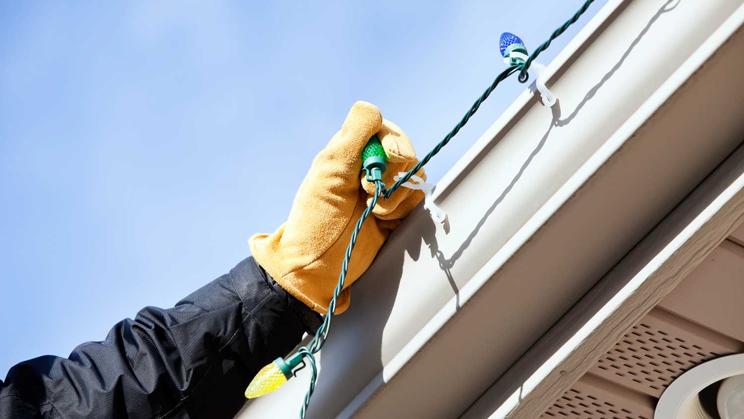 Hand attaching Christmas lights onto clips