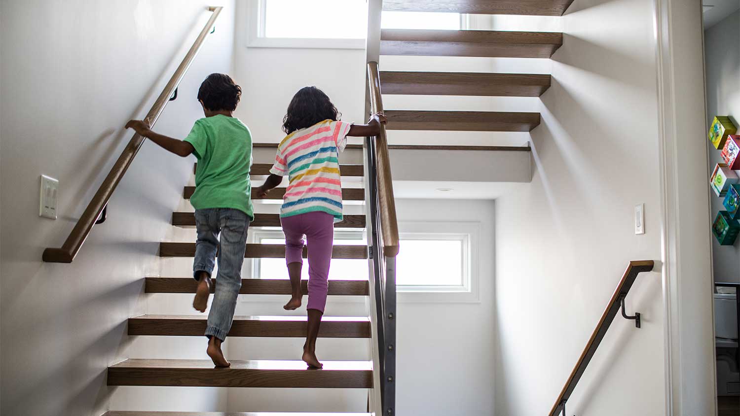 Two children walk up stairs