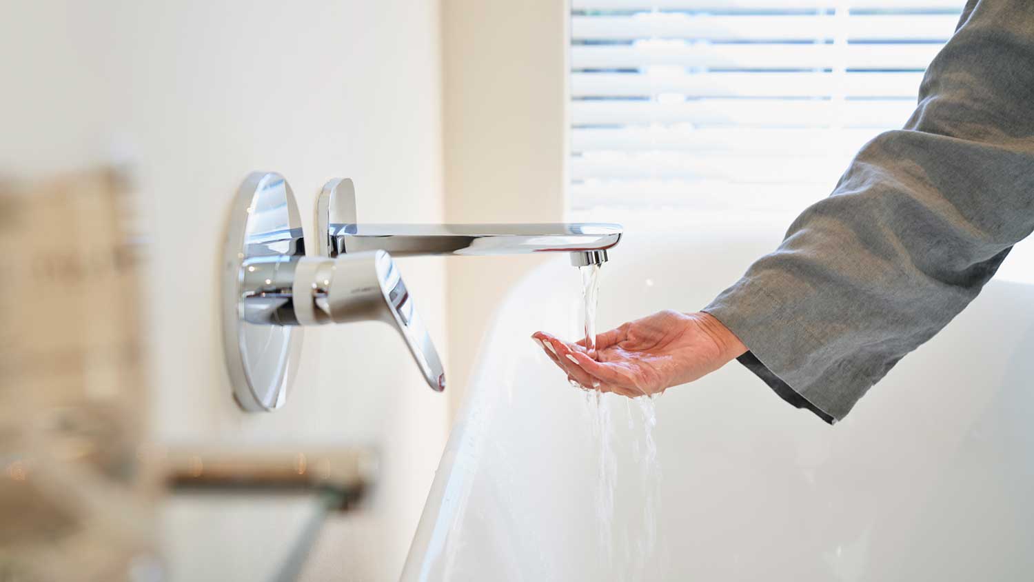 Woman checking water temperature before taking a bath
