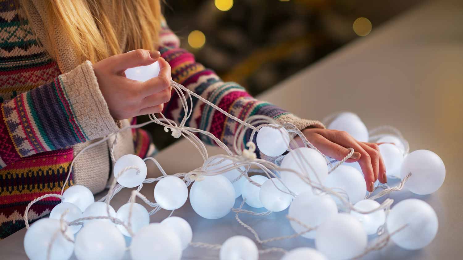 A woman untangling Christmas lights