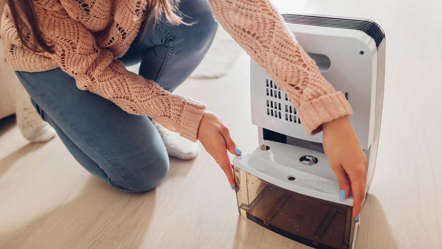 A woman using a dehumidifier in a room