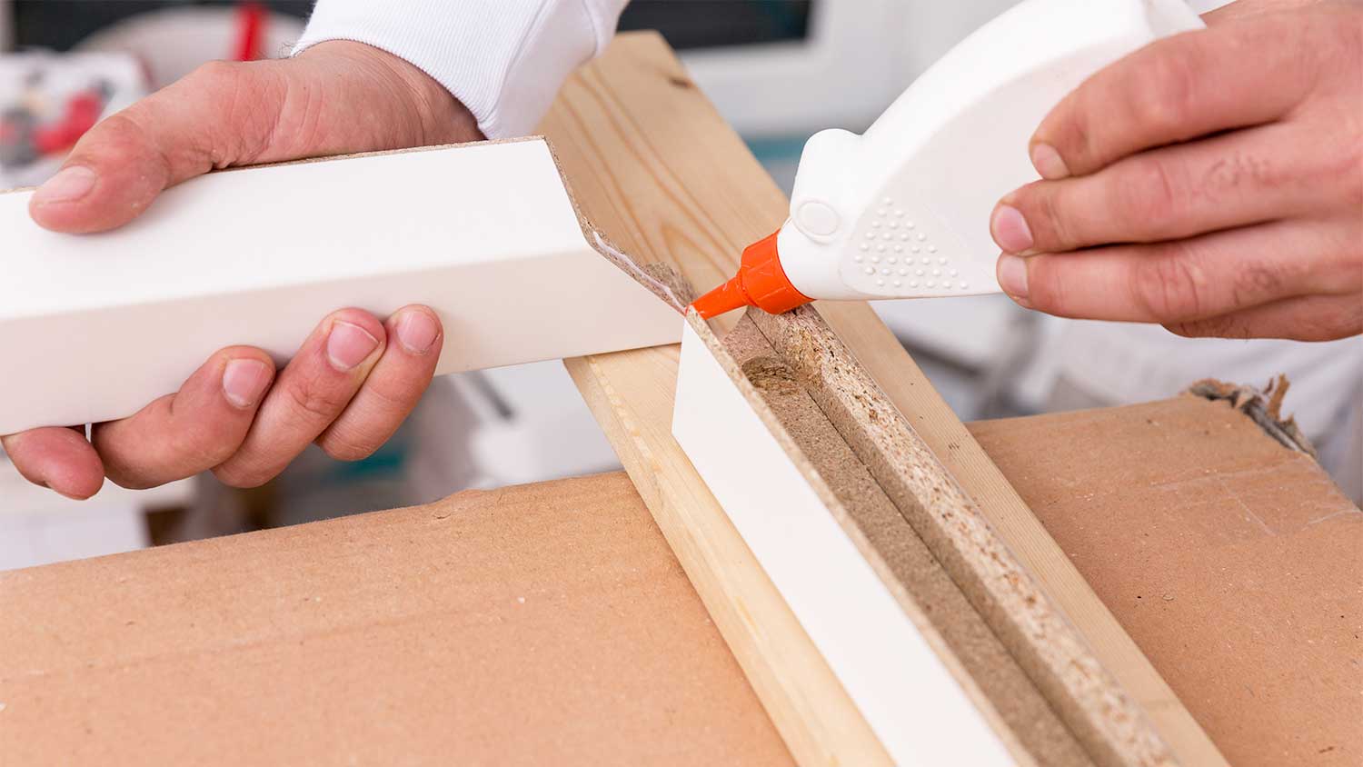 A view of someone using wood glue on a doorframe