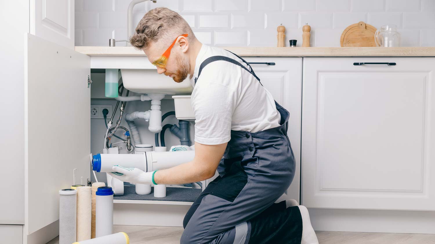 A professional installing a water filter beneath a sink