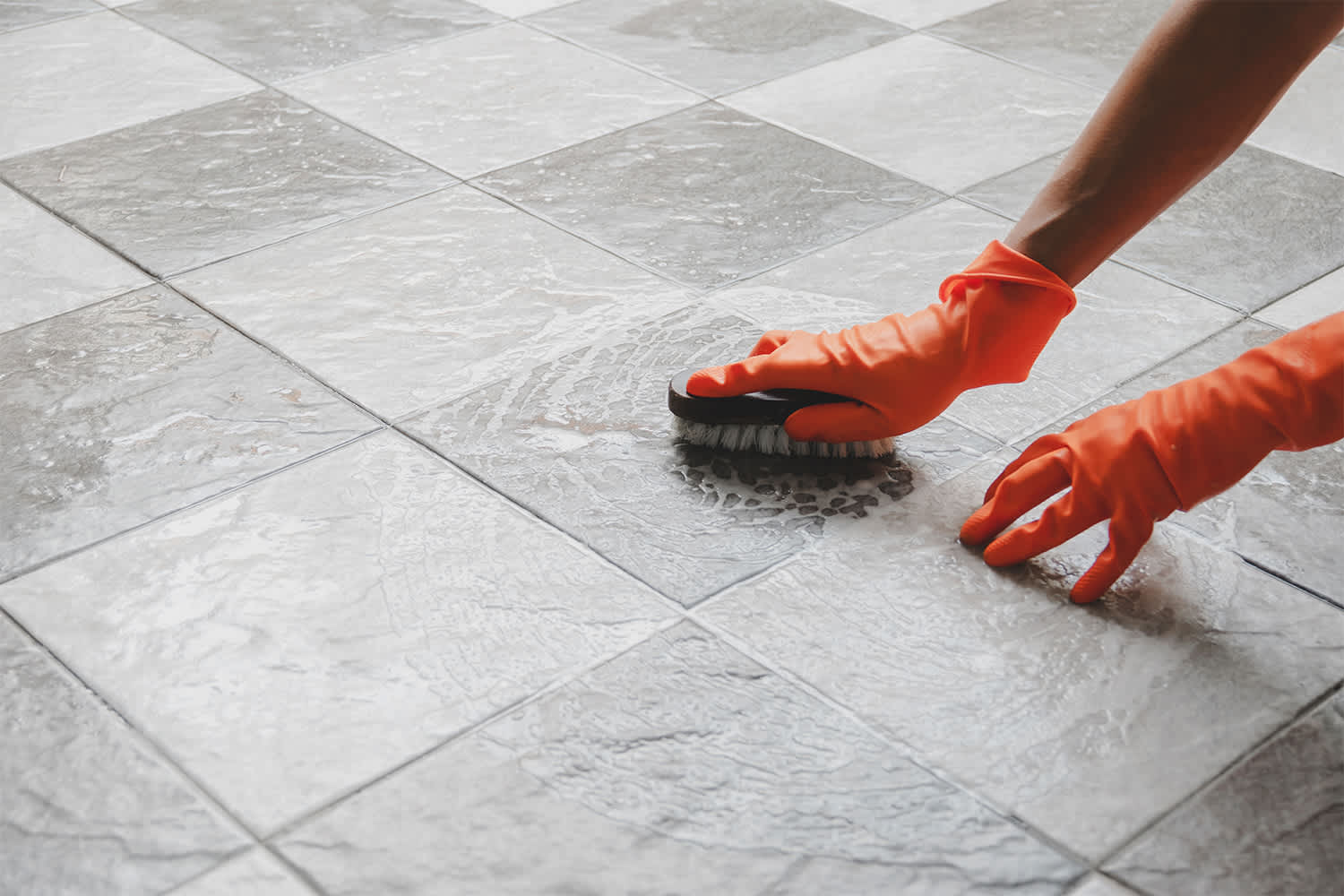 Person cleaning tile floor after flooding