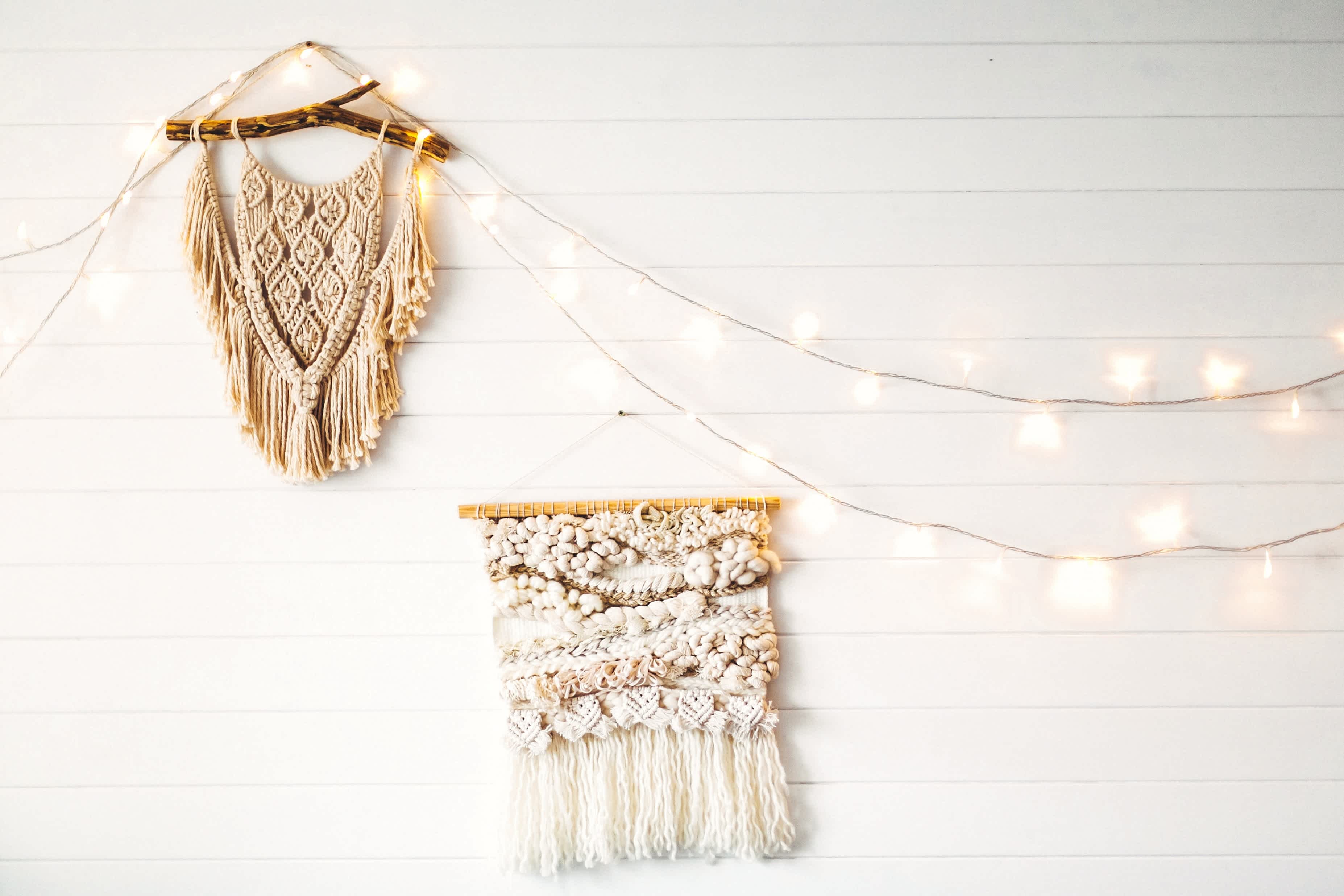Macrame and string lights hanging on white shiplap wall