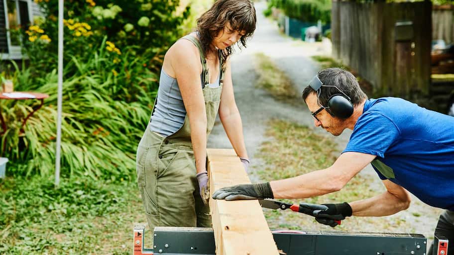 Couple cutting a board in the backyard