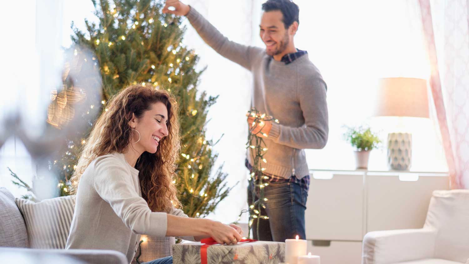 Couple hanging lights on a tree